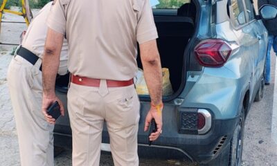 सड़क पर रोके गए वाहन की बारीकी से जांच करती पुलिस टीम