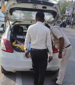 संदिग्ध गतिविधियों पर नजर, कार की डिक्की की तलाशी लेते पुलिसकर्मी