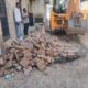 नारनौल के मोहल्ला गुदड़ी में अतिक्रमण हटाते हुए नगर परिषद की टीम, जेसीबी से अवैध दीवार को तोड़ा गया।