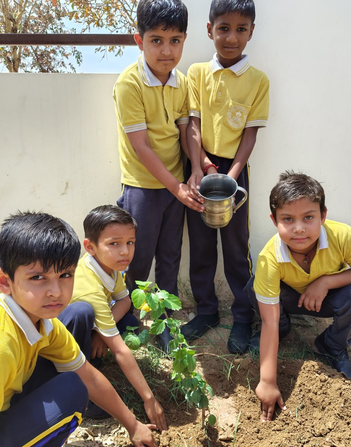 पौधा लगाते हुए बच्चे
