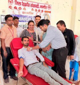 रक्तदाताओं को बैज लगाते एसडीएम अनिरुद्ध यादव।