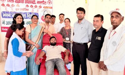 मानव सेवा की मिसाल: रक्तदान करते युवक के साथ उपस्थित अधिकारी व समाजसेवी