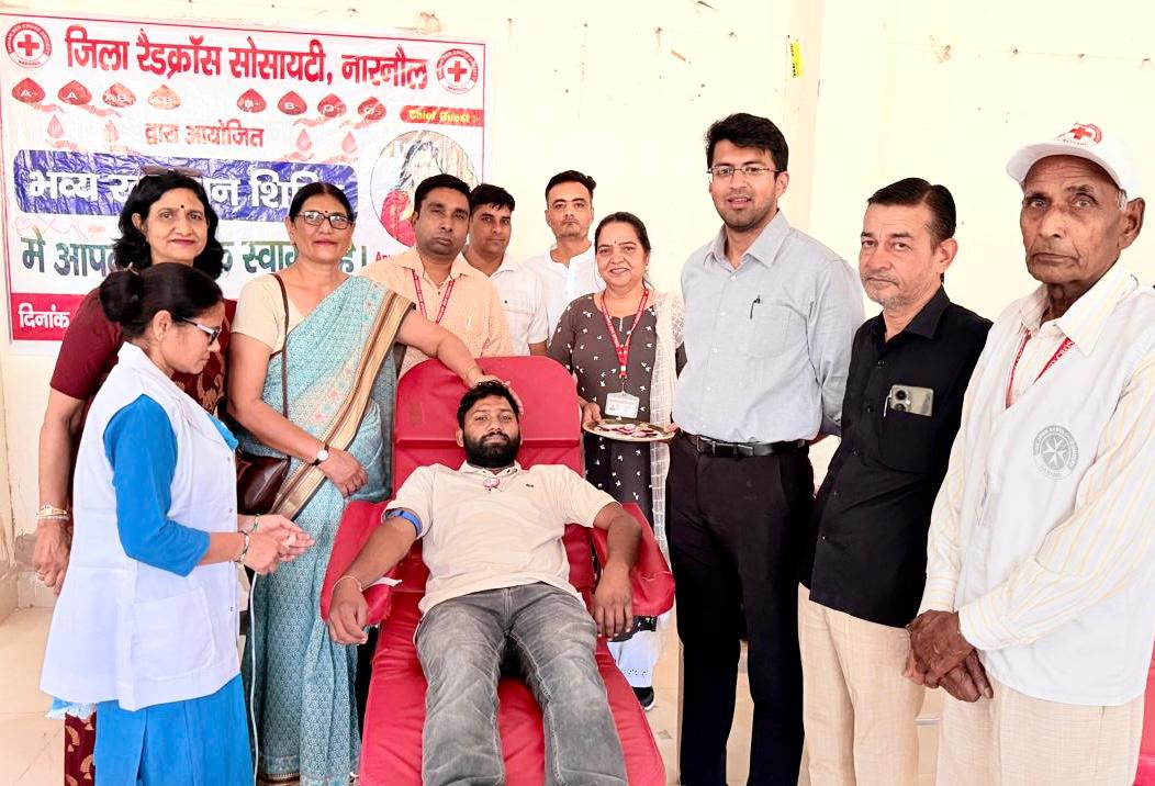 मानव सेवा की मिसाल: रक्तदान करते युवक के साथ उपस्थित अधिकारी व समाजसेवी