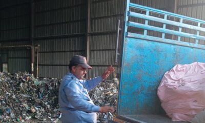 पिकअप में डालते प्लास्टिक कचरा।