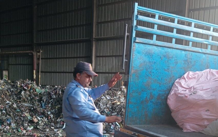 पिकअप में डालते प्लास्टिक कचरा।