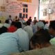 बैठक के दौरान मंच पर मौजूद पदाधिकारी और सामने बैठे कर्मचारी, समस्याओं को लेकर गंभीर चर्चा।