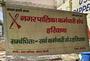 नांगल चौधरी में नगर पालिका कर्मचारी संघ हरियाणा का बैनर, कर्मचारियों के आंदोलन का बना प्रतीक।
