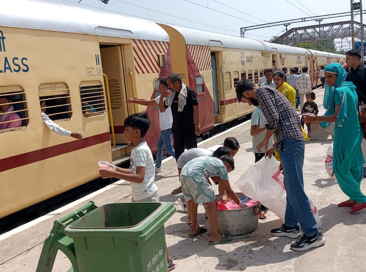 नारनौल रेलवे स्टेशन पर दैनिक रेलयात्री जागरूक मंच द्वारा यात्रियों को ठंडा पानी और शरबत वितरित करते सदस्य।