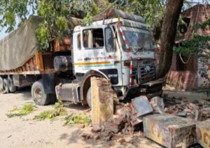 स्कूल का मेन गेट तोड़ने के बाद पेड़ से टकरा कर रुका ट्राला।