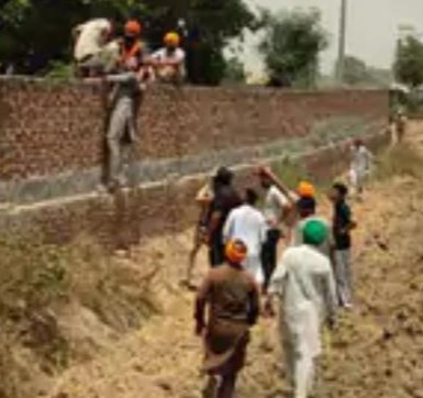 दीवार फांदकर श्मशान घाट में जाते लोग।