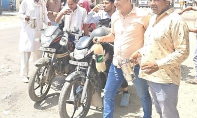 ताऊ देवीलाल चौक निजामपुर में राहगीरों को ठंडा पानी पिलाते समाजसेवी और युवा।