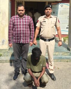 साइबर अपराध के खिलाफ कार्रवाई के दौरान पुलिस अधिकारियों के साथ आरोपी।