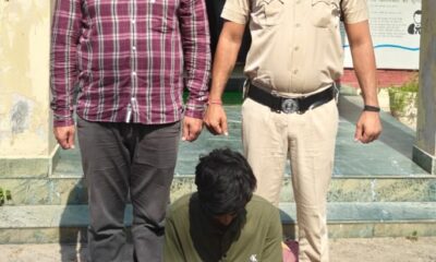 साइबर अपराध के खिलाफ कार्रवाई के दौरान पुलिस अधिकारियों के साथ आरोपी।