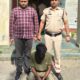 साइबर अपराध के खिलाफ कार्रवाई के दौरान पुलिस अधिकारियों के साथ आरोपी।