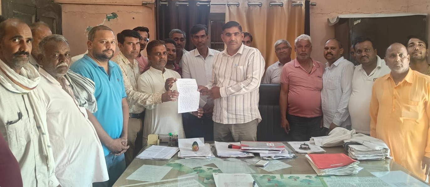 वन राजिक अधिकारी रजनीश यादव को लिखत शिकायत देते ट्रैक्टर चालक और आरा मशीन संचालक