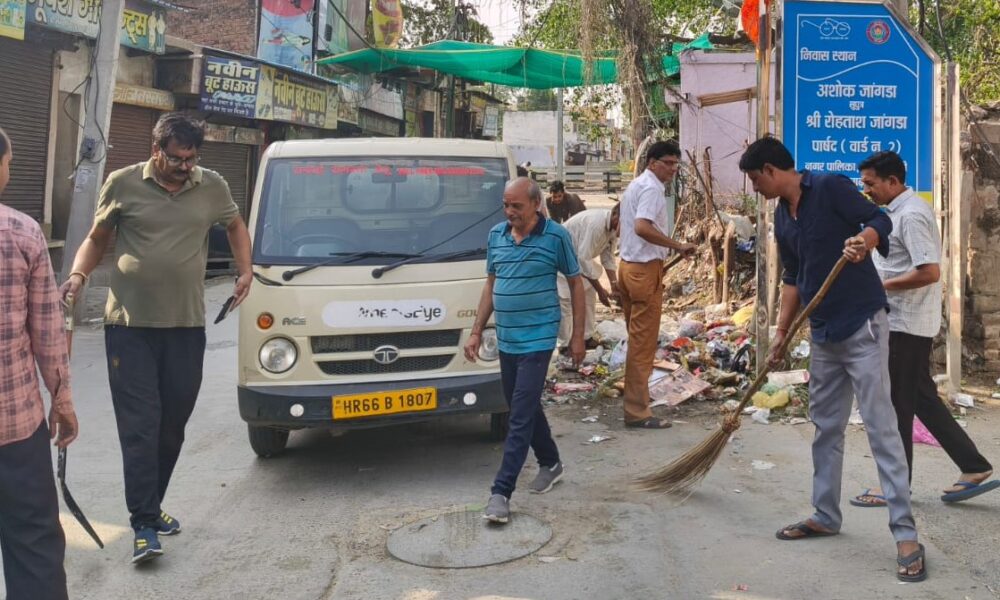 अटेली में कचरा डालते हुए जनप्रतिनिधि व अन्य।