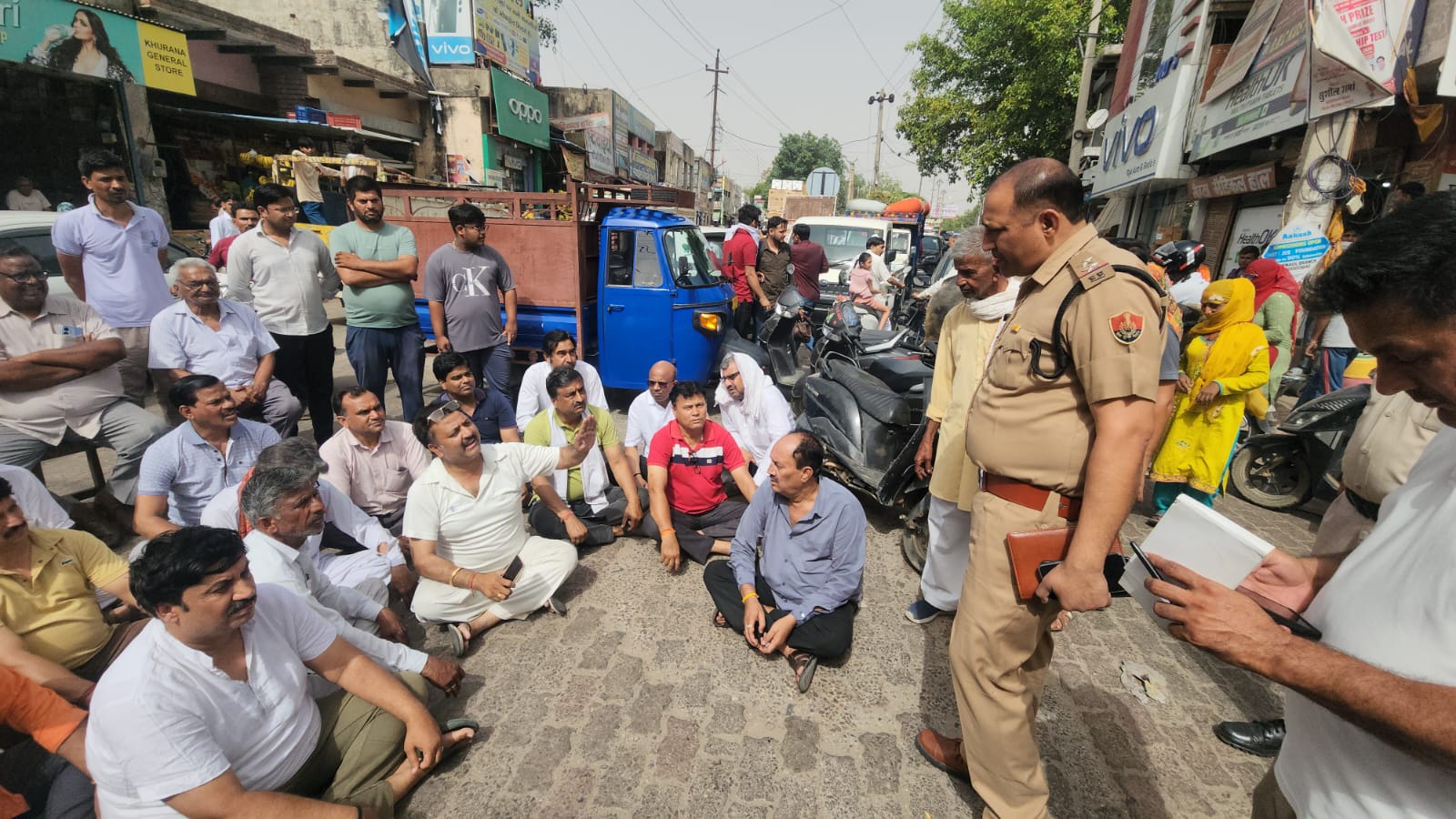 शहर के बालाजी चौक पर धरने पर बैठे लोग।