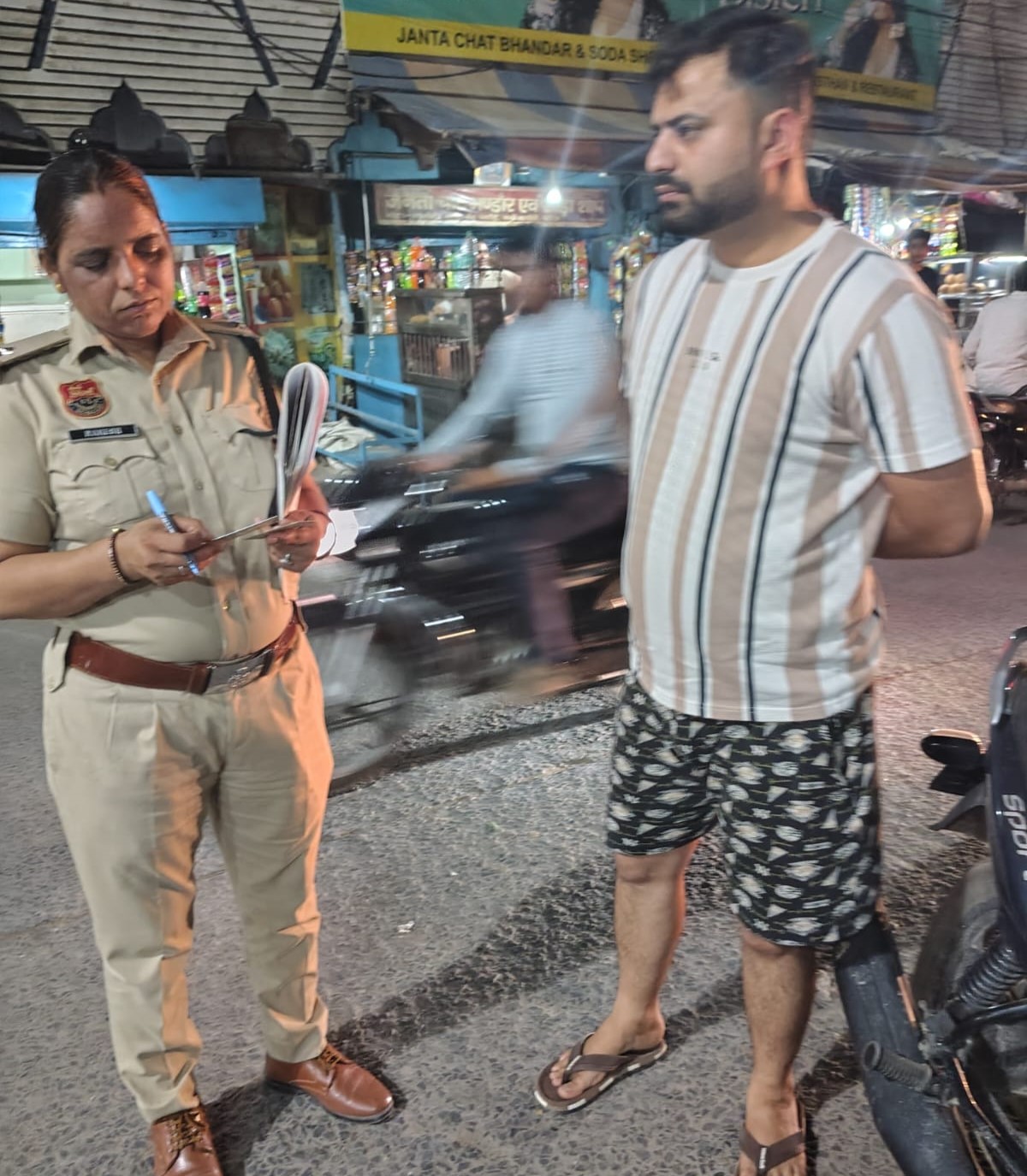 शहर में चलाए गए विशेष अभियान के दौरान ट्रैफिक नियमों का उल्लंघन करने वाले वाहन चालक का चालान करती महिला पुलिस अधिकारी।