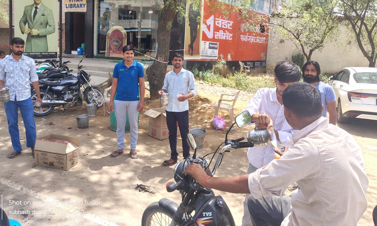 अटेली-कनीना रोड़ पर राहगीरों को ठंडा मिठा पानी पिलाते दुकानदार,