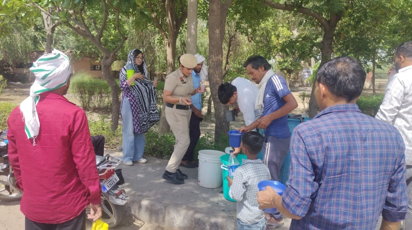 लघु सचिवालय नूंह के मुख्य द्वार पर राहगीरों को मीठा ठंडा पानी पिलाते नूंह पुलिस के जवान।
