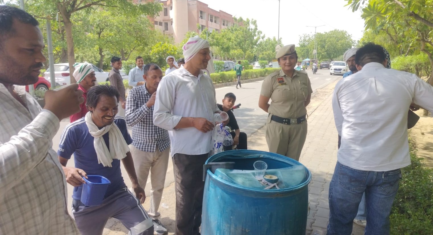 जनसेवा की मिसाल पेश करते हुए लघु सचिवालय परिसर में लोगों को पानी वितरित करते पुलिसकर्मी।