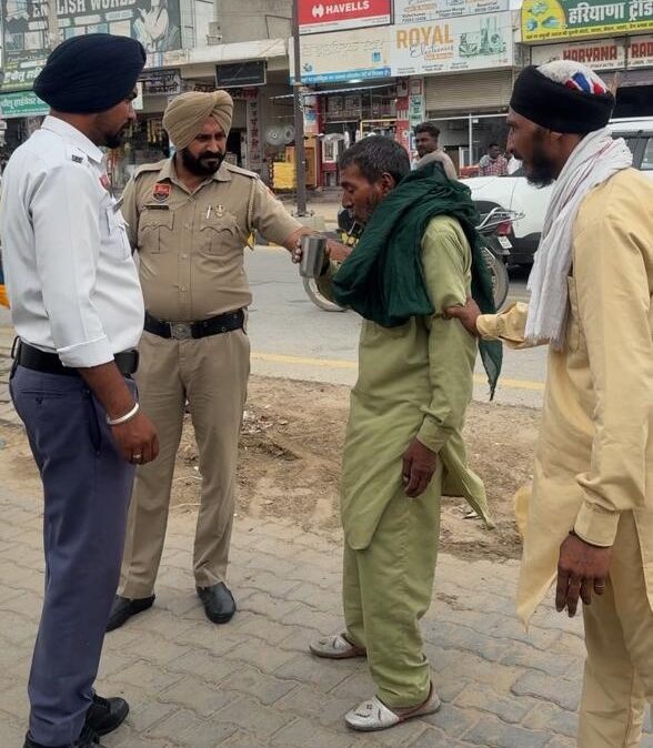 रतिया ट्रैफिक पुलिस द्वारा सड़क पर बेसुध पड़े व्यक्ति की सहायता करते पुलिसकर्मी।