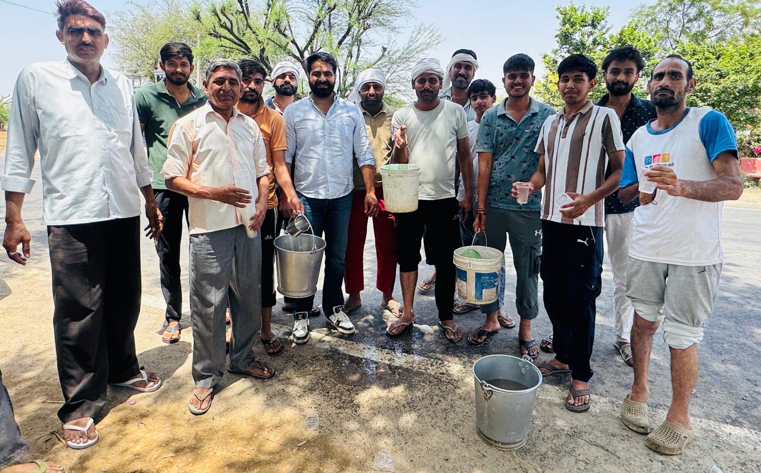छिलरो गांव के बस स्टैंड पर राहगीरों को शरबत पिलाते युवा और पौधारोपण का संकल्प लेते ग्रामीण।