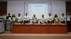 स्मारिका विमोचन करते अतिथि, मंच पर मौजूद विश्वविद्यालय के अधिकारी