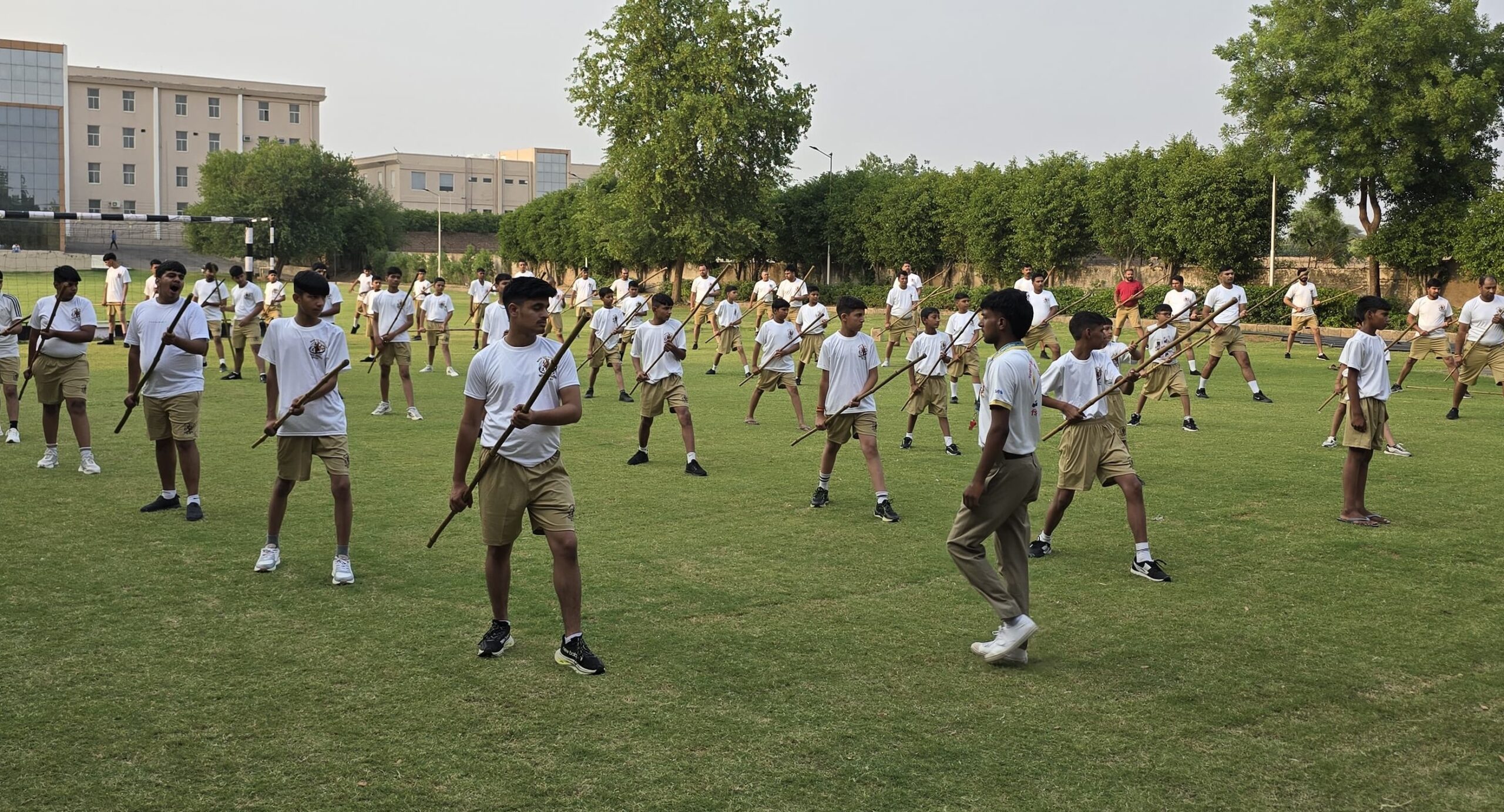 शिविर में लाठी चलाना सीखते युवा।