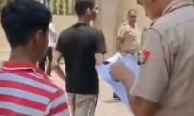 नारनौल में गर्ल स्कूल के सेंटर के बाहर खड़ी छात्रा के रोल नंबर देखते पुलिसकर्मी