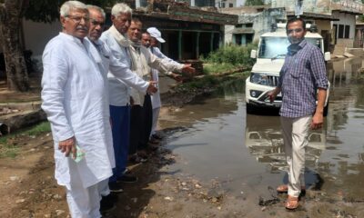 सड़क पर जमा गंदे पानी का निरीक्षण करते हुए नेताजी अतरलाल व ग्रामीण।