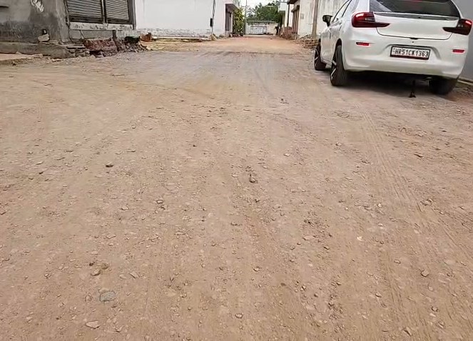 राधेश्याम कॉलोनी में अधूरी सड़क और उड़ती धूल का दृश्य
