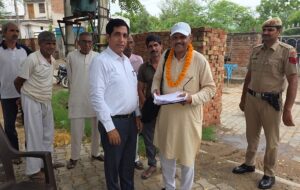 समय पर कार्य पूरा करने के लिए बीएलओ को सम्मानित करते एसडीएम डॉ. जितेंद्र सिंह।