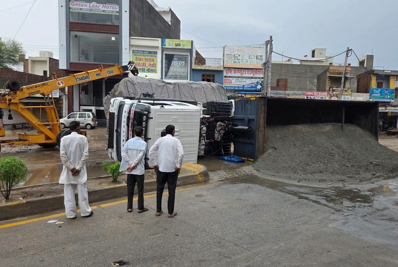 भूना में मेन रोड पर पलटे ट्राले को क्रेन से उठाने में जुटा ड्राइवर।