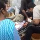 गंडासे से कलाई कटने के बाद रणजीत सिंह का उपचार करते स्वास्थ्यकर्मी।