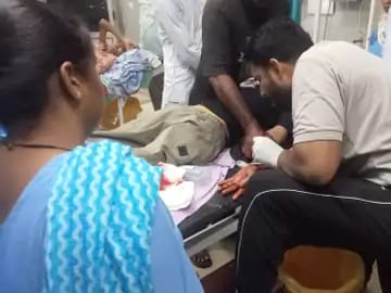 गंडासे से कलाई कटने के बाद रणजीत सिंह का उपचार करते स्वास्थ्यकर्मी।